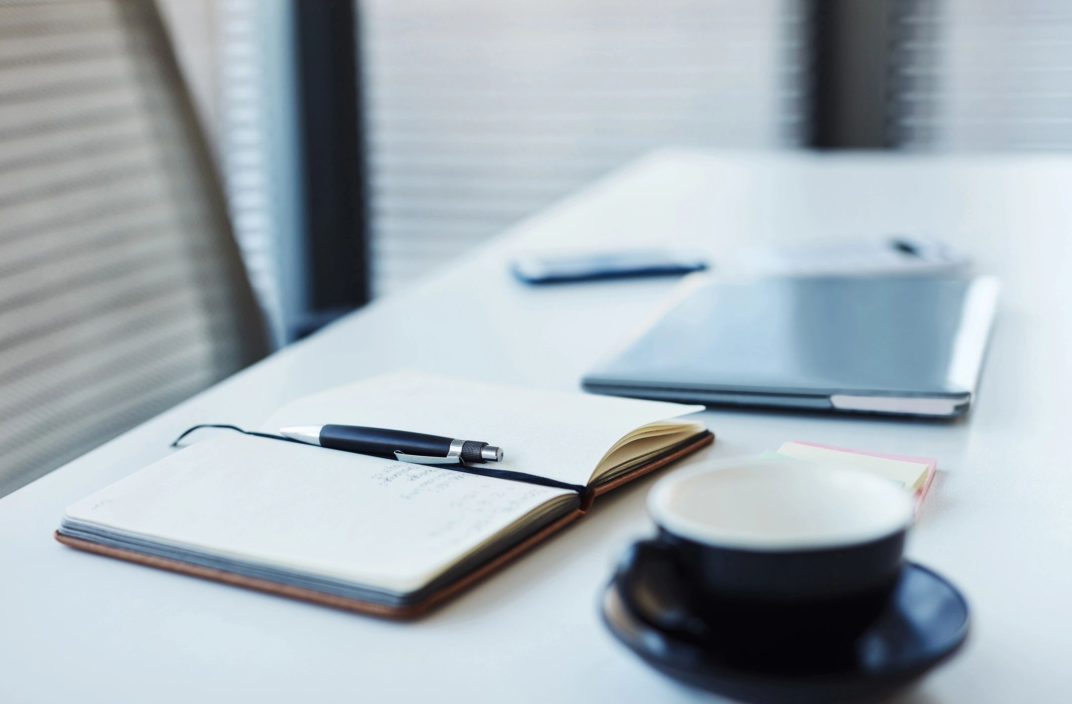 Notebook and laptop on a tablet in an office workspace